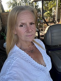 Author, Kari Goin, standing in front of a golf cart getting ready to train dogs.